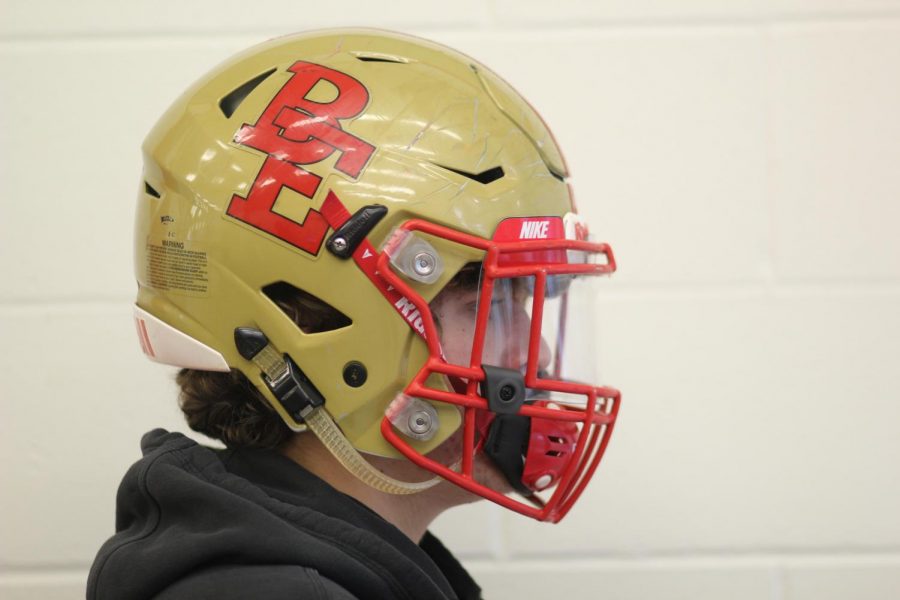 Current football player , Isaiah Jenner, poses for picture with his helmet.