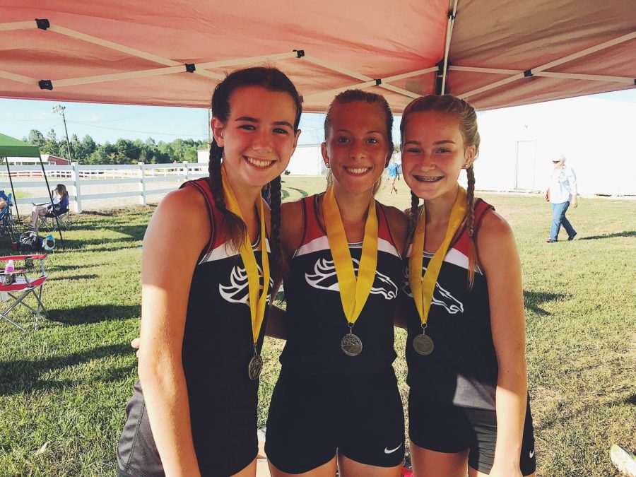 Sophomore Mia Maguire (left), junior Emily Tinelli (middle) and freshman Raelee Hawkins (right) all excelled in their meet Sept. 14. All three girls placed in the top 10 out of 69. Coach Lenny Raley calls them the three-headed monster because of their alike hardworking mentalities. 