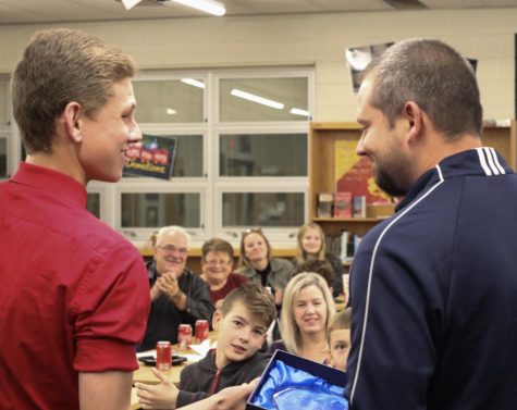 Senior Aiden Robison handing the “Region 5 Coach of the Year” award to Coach Kyle Downs. During Robison’s speech, he pulled out a gift bag, with an award for Downs being named the “Coach of the Year,” from their regionals match. “I didn’t do anything different this year than I did in any other past years. You know, you win awards, and you don’t win awards, and it’s always nice to win it, but it’s not something that I look forth, at the beginning of the year,” said Downs, “It’s cool to get it, I’ve gotten it twice. You know, I’m two time defending FBLA Region Adviser of the Year, and you know, they’re cool to get; to get awards and stuff like that, it means that you’re kind of doing a good job, but it also means that you have good people around you, you have good players, you have good support, and at the end of the day, it’s an award, and it’s nice to have, but, you know it’s not about me, it’s about the kids, and as long as they’re being successful, then I’ll be fine whether I get one of those, or not.”