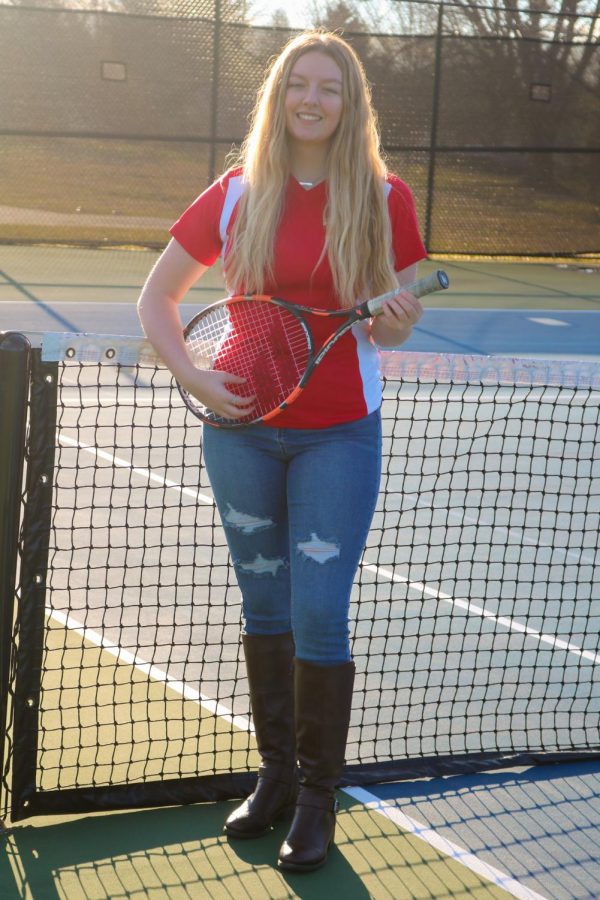 Senior Megan Weihe playing her tennis racquet, like a guitar, wearing a tennis shirt, and a pair of blue jeans. Weihe is a multi-talented person, ranging from the sport of, to the art form of singing. “I feel like they’re (her talents) very different, for me, in that: tennis is an escape from the world, and my emotions, and music is expressing my emotions, and how I feel,” said Weihe.