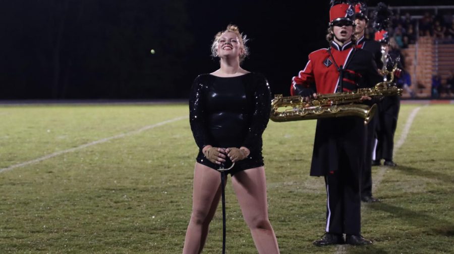 Color guard member stands tall with enthusiasm finishing a great performance at the Grayson County High School marching band competition. 