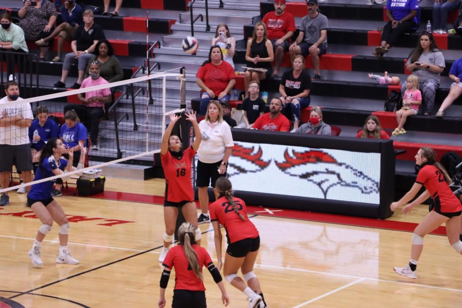 Senior Emily Huntsman sets the ball in the air as Emma Brogan goes in to spike the ball.