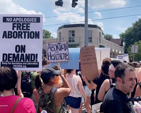 Protesters march down the street holding signs in the aftermath of Roe v. Wade being overturned. On July 4, 2022, citizens gathered in downtown Louisville, Kentucky on Baxter Avenue to show their distain to the state for its proposed abortion ban.