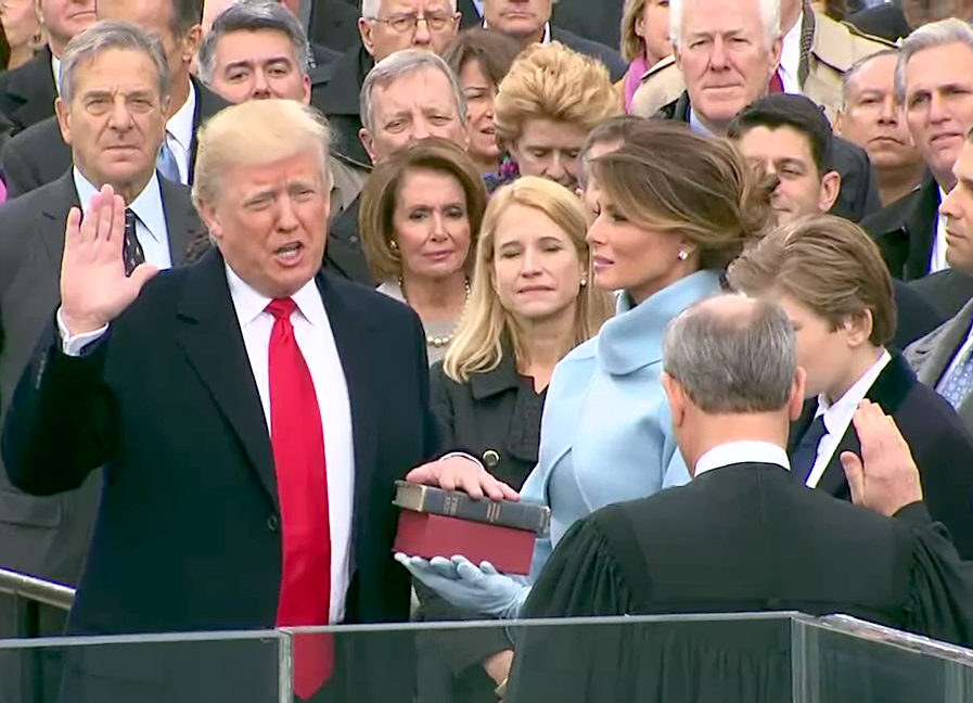Trump holds his hand on the Bible as he swears in to be the next president.
