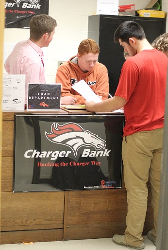 Jake Reece, Mark Murphy, and Micheal Lobred looking over notes and loan paperwork.  