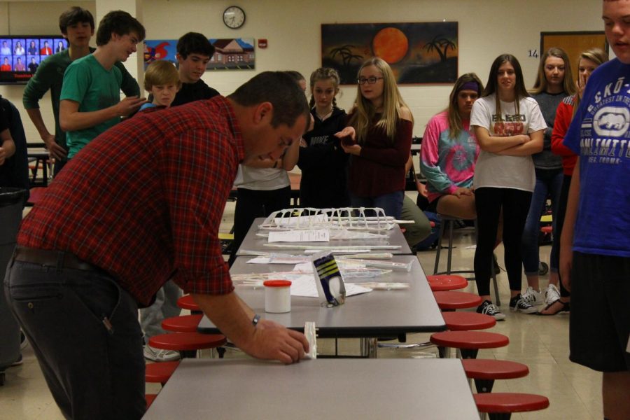 Mr.Dickerson testing out a bridge built by one of the groups during the STEM challenge. 