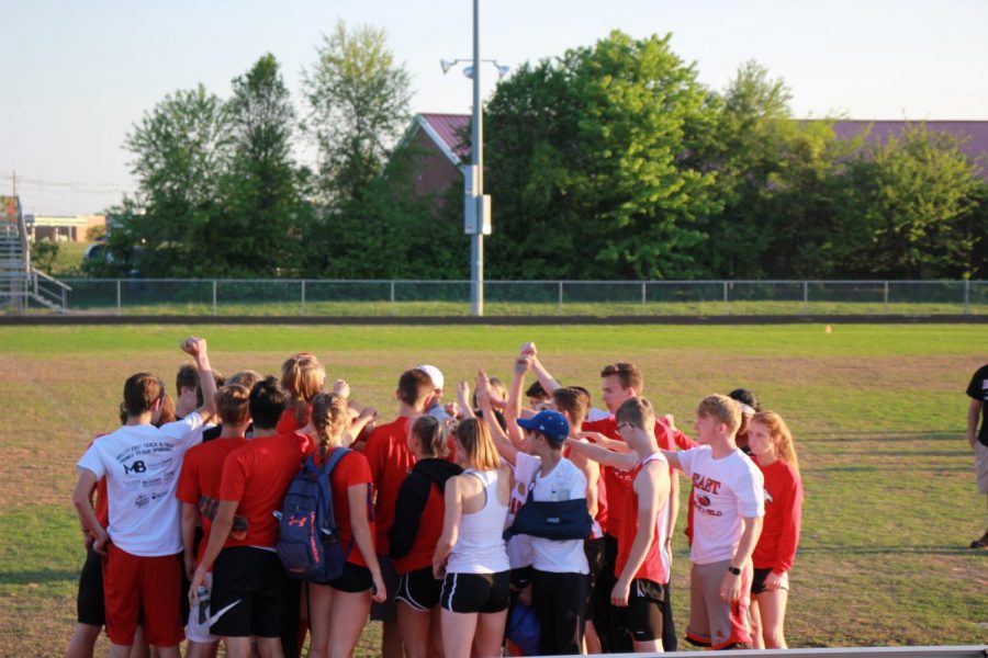 The team getting together before a meet in a huddle. 