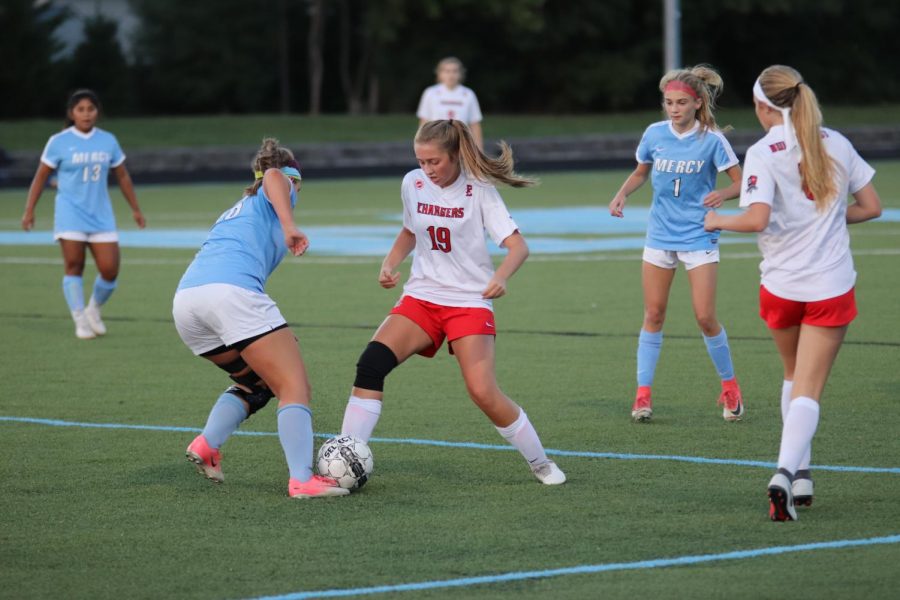 Junior Chloe Holt fighting for possession of the ball in the girls soccer game against Mercy. The Chargers have beat Mercy twice this year, and are looking for another win this upcoming Friday. "Chloe is a great player and exerts confidence when she carries the ball," said Mahoney. 