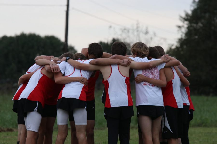 Boy runners huddle up for a pre-run pep talk. 