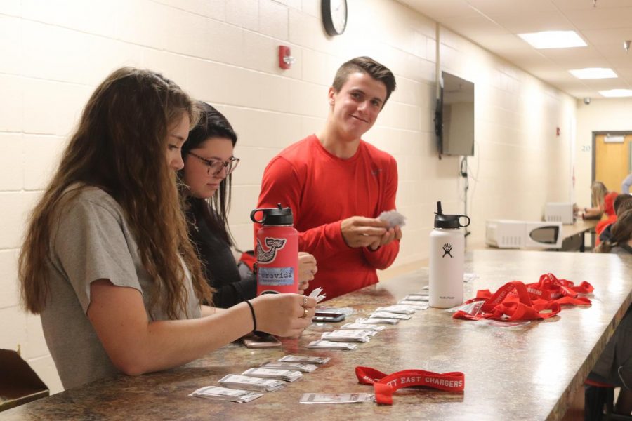 Junior Aeron Adams handing out PBIS barcodes and lanyards with fellow SLAM class peers at lunch. With the new rewards system each student has to have their own code for teachers to scan and give them points. "Positive behavior will influence good vibes throughout the school," said Adams. 