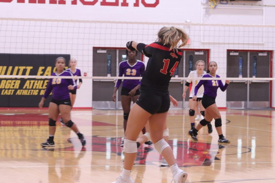 Junior Emily Popplewell passes the ball over the net. The Lady Chargers won this game against Bardstown High School. Senior Halle Key said, "It felt great to win the first home game. The student section really showed out tonight, so I hope it's like this every home game."
