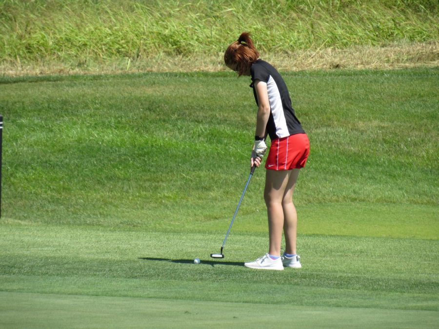 Putting the golf ball, senior Abi Huffman about to make her final shot into the hole. On Aug. 24 the girls golf team competed in a tournament at their home course, Heritage Hill. "Our scores all went down which is really good," said Huffman.