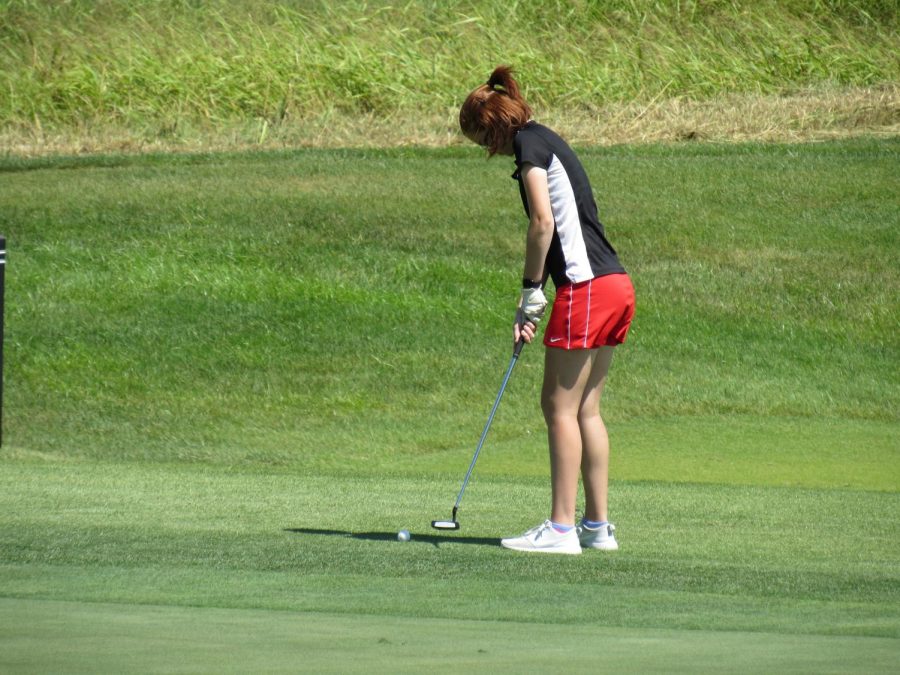 Putting the golf ball, senior Abi Huffman about to make her final shot into the hole. On Aug. 24 the girls golf team competed in a tournament at their home course, Heritage Hill. Our scores all went down which is really good, said Huffman.