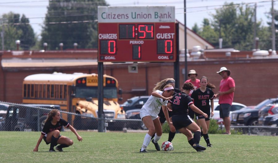 Fighting for possession, seniors Brooke Montague and Ryley Ortega try to keep Owensboro Catholic from scoring. This was their first home game of the season and resulted in a tie.