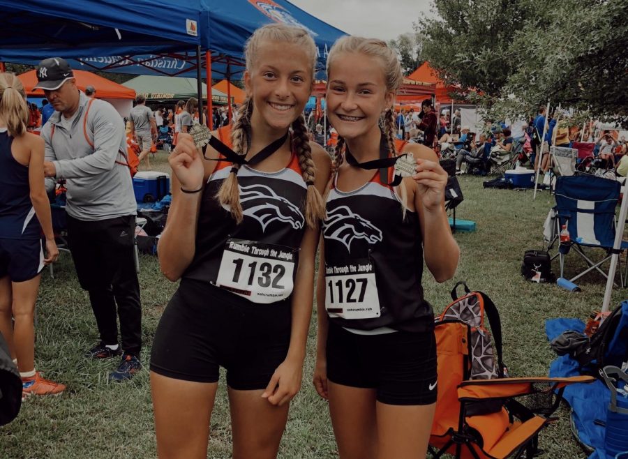 Freshman Raelee Hawkins and junior Emily Tinelli show off their placement medals. They placed high in last weekend's Hillbilly Run.