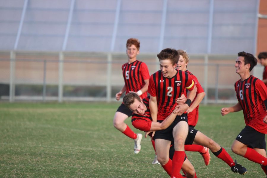 Zak Perdew (middle) and his teammates celebrating after Perdew scores the winning goal.