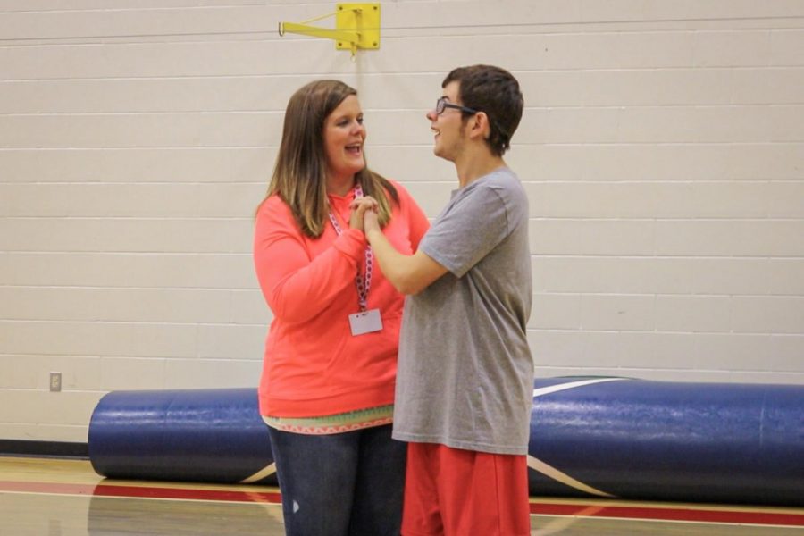 Celebrating junior Braden High's homerun, Instructional Assistant Katie Hoben is congratulating High on his hard work and dedication while playing baseball. Bullitt East offers two adaptive classes, P.E. and music alive, which contains  special needs students along with peer partners. "We support inclusion in the classroom, the hallways, in sports, and in our everyday life," said Hoben.