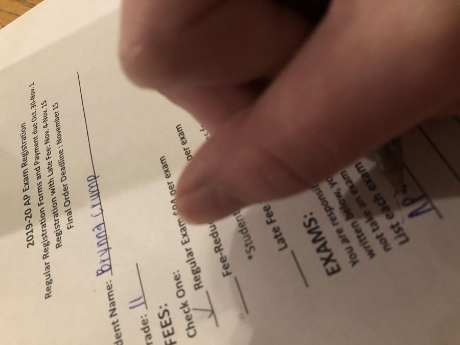 Filling out a registration paper, Brynna Crump signs up for her AP exams. AP exam registration took place between Oct. 30, 2019 till Nov. 1, 2019 . "I'm taking two AP exams this year, AP lang and AP US history. I've got a five and a three in the past so I'm hoping for both fours this year," said Crump, junior.