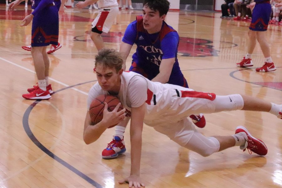 Senior Hunter Brogan falls in an effort to keep the ball. The team beat Scott Co. 80-69. Brogan said, I think the first week went really good, we show a lot of potential and things are only going to get better.