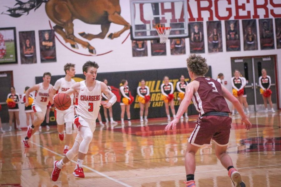 Senior Zak Perdew taking the ball down the court hoping to score. Perdew led the team this game with a total of 23 points, and a final score of 52-45. 