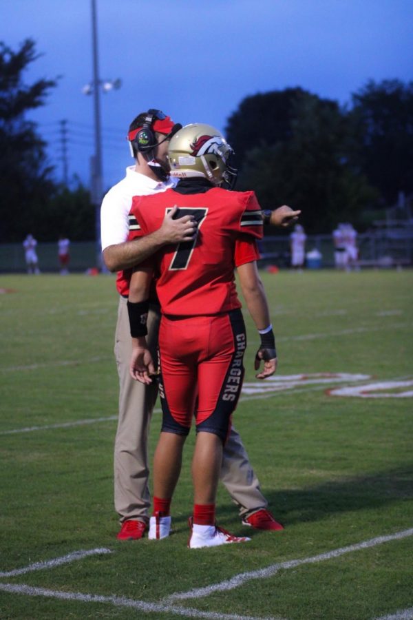 Head Football Coach Ethan Atchley talking to freshman Jack Zwernemann about a plan, at the Sept. 11 Christain Academy versus Bullitt East football game.  “I think our players have done a great job of accepting constant change, and adapting. They’ve been willing to go through a whole lot of different procedures that we have been asked to place. We have a lot of different things to try and keep our kids, and community, safe, but still give the kids an opportunity to play football,” said Receivers Coach Tyler Faucett.