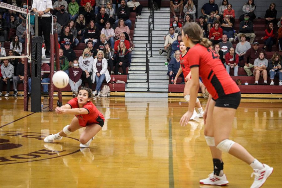 Senior Emily Huntsman dives to save the ball after Holy Cross tips it over the net.