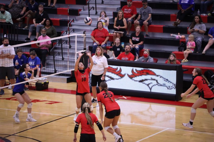 Senior Emily Huntsman sets the ball in the air as junior Emma Brogan goes in to spike the ball.