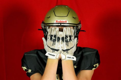 Senior Mason Gauthier poses with his clown gloves on fall Media Day 2022.  Photographer: Raegan Jackson