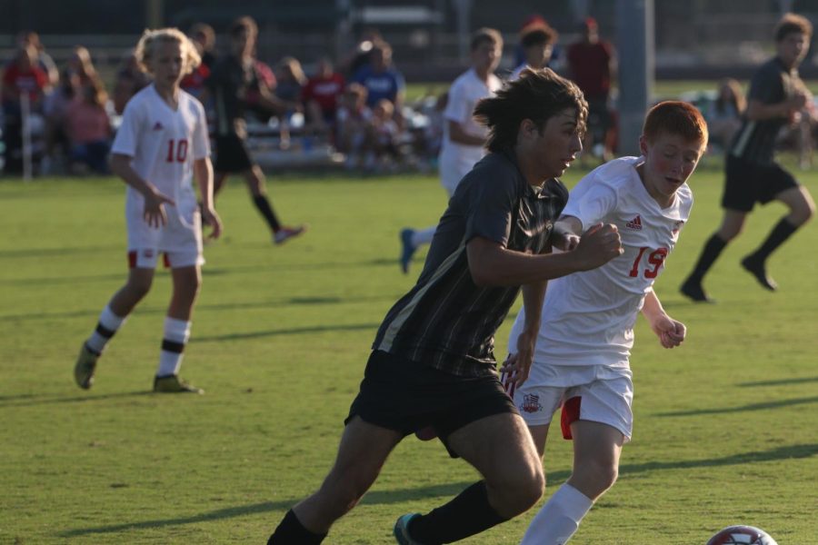 Landon Tally dribbles down the field weary of the defense to the left of him. On Aug. 13 the boy's team played Bullitt Central and North Bullitt in the anual Bullitt cup. "I think we went into it knowing we were going to do well, but there's still some things we need to work on," Tanner Chitwood said. 