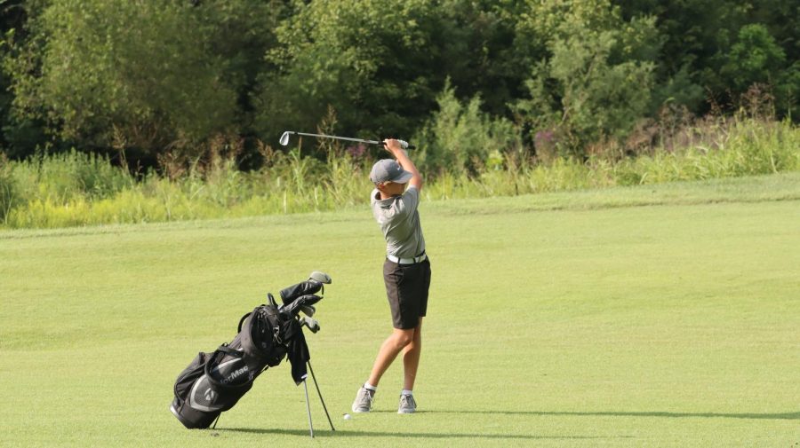 Freshman Isaac Lewis hits his third shot on the par five number four at Heritage Hill Golf Club.