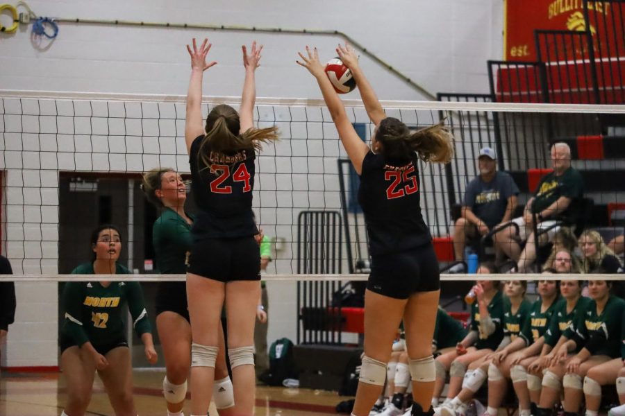 Emma Brogan going up for a block. Katherine Cissell is next to her. "We all had a lot more determination to win that game because it was a rival," senior Hayla Puckett said