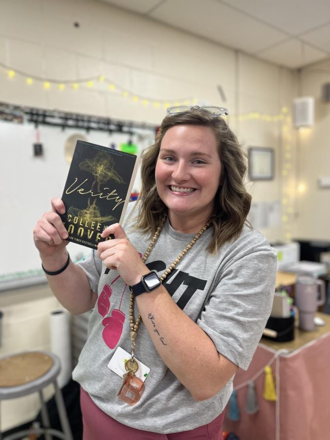 English teacher, Brook Stivers stands with a copy of "Verity", one of Colleen Hoovers most popular novels.