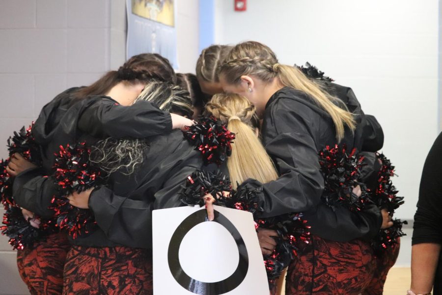 The dance team gathers before a performance, hoping for the best outcome for their hard work. The girls have practiced hard all season and are continuing to improve with every step and every fall. “Just getting out there and making a name for the team is motivation…the team isnt very represented so I think its nice to make a good name for the team and show people what we do, thats motivating,” senior dancer Katelyn Powers said. 