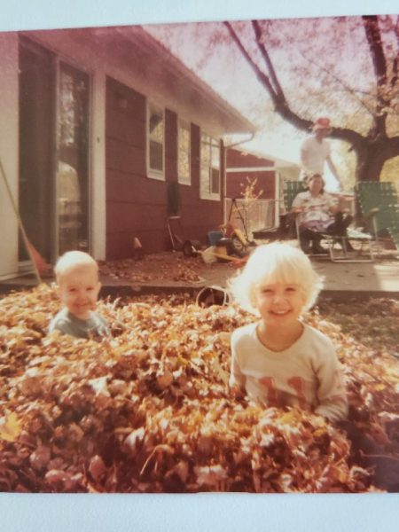 Two young siblings enjoying the fall leaves, 1979.