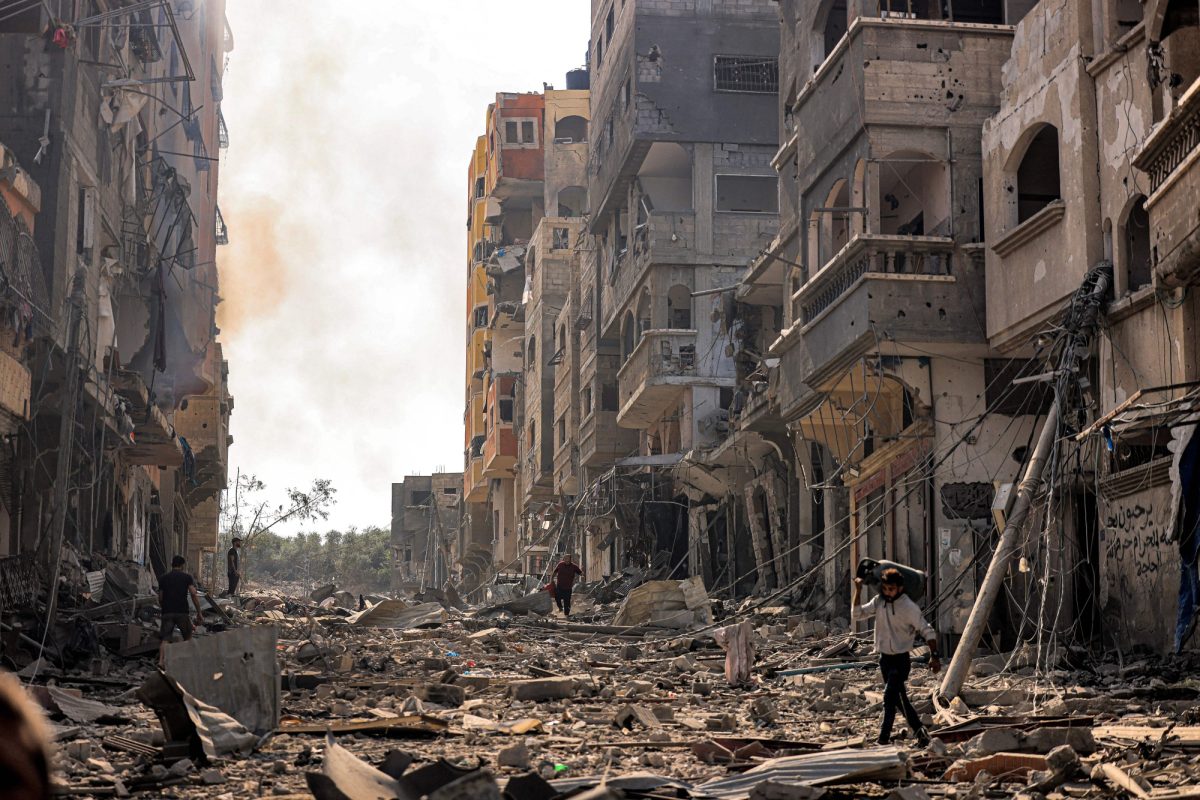 Civilians walk through the crumbling streets of Gaza City after an IDF assault leaves neighborhoods in ruin. (Oct. 11).