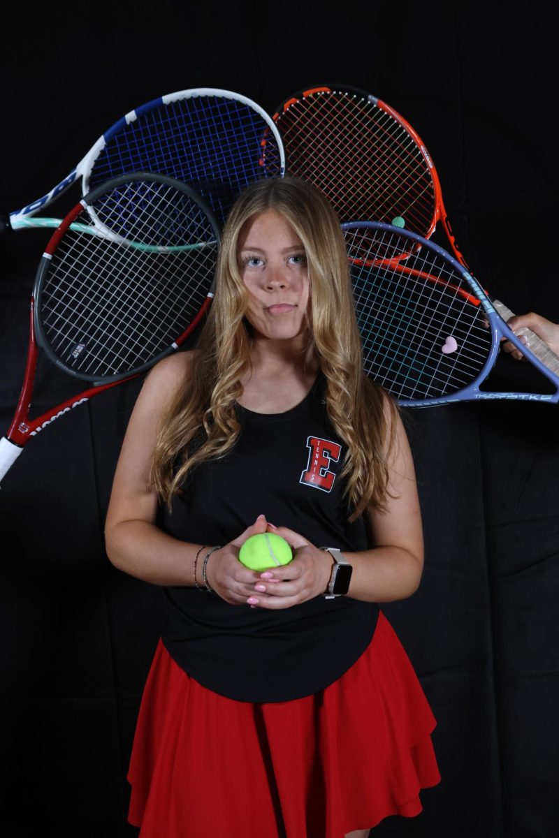 Tessa Tibone surrounded by tennis rackets.