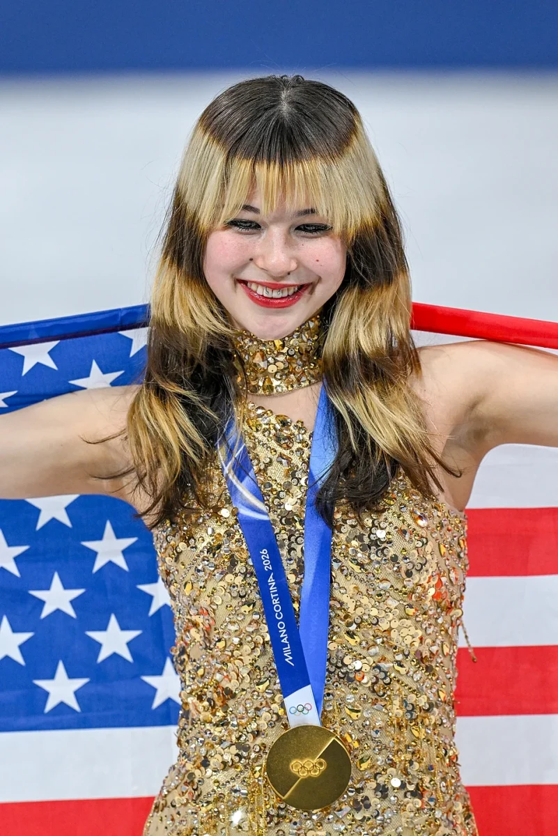 Alysa Liu is pictured accepting her medal and posing with an American flag.